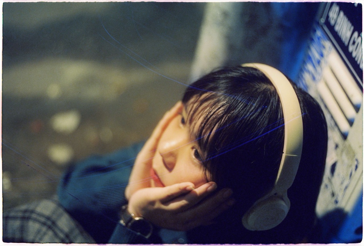 Indonesian youth with headphones in a vibrant street scene