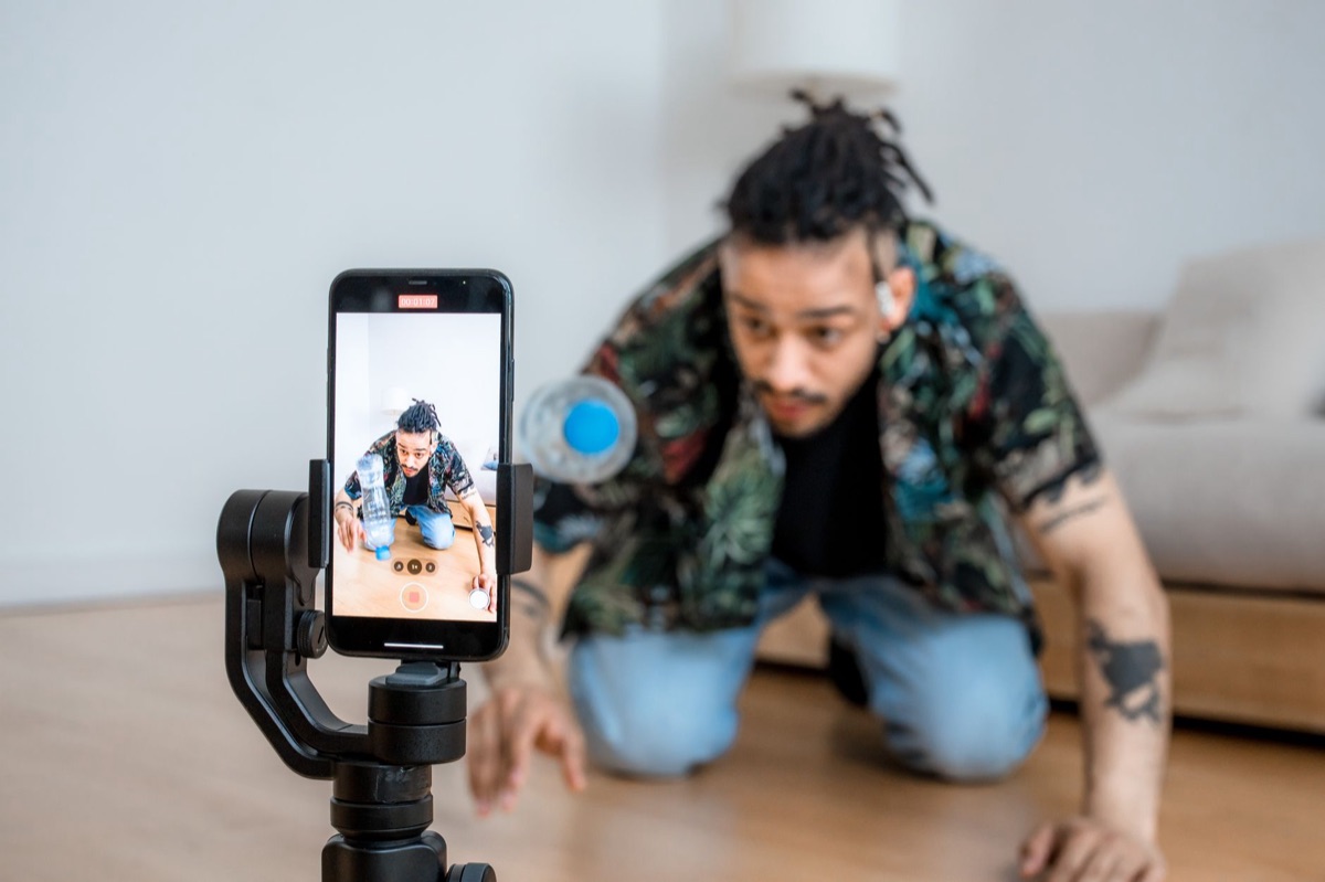 YouTuber filming dance challenge in Indonesia with digital trend backdrop