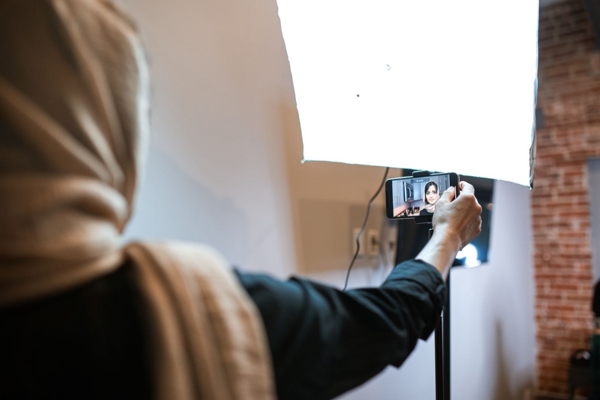 Une influenceuse indonésienne dans un studio avec une caméra et un tableau blanc