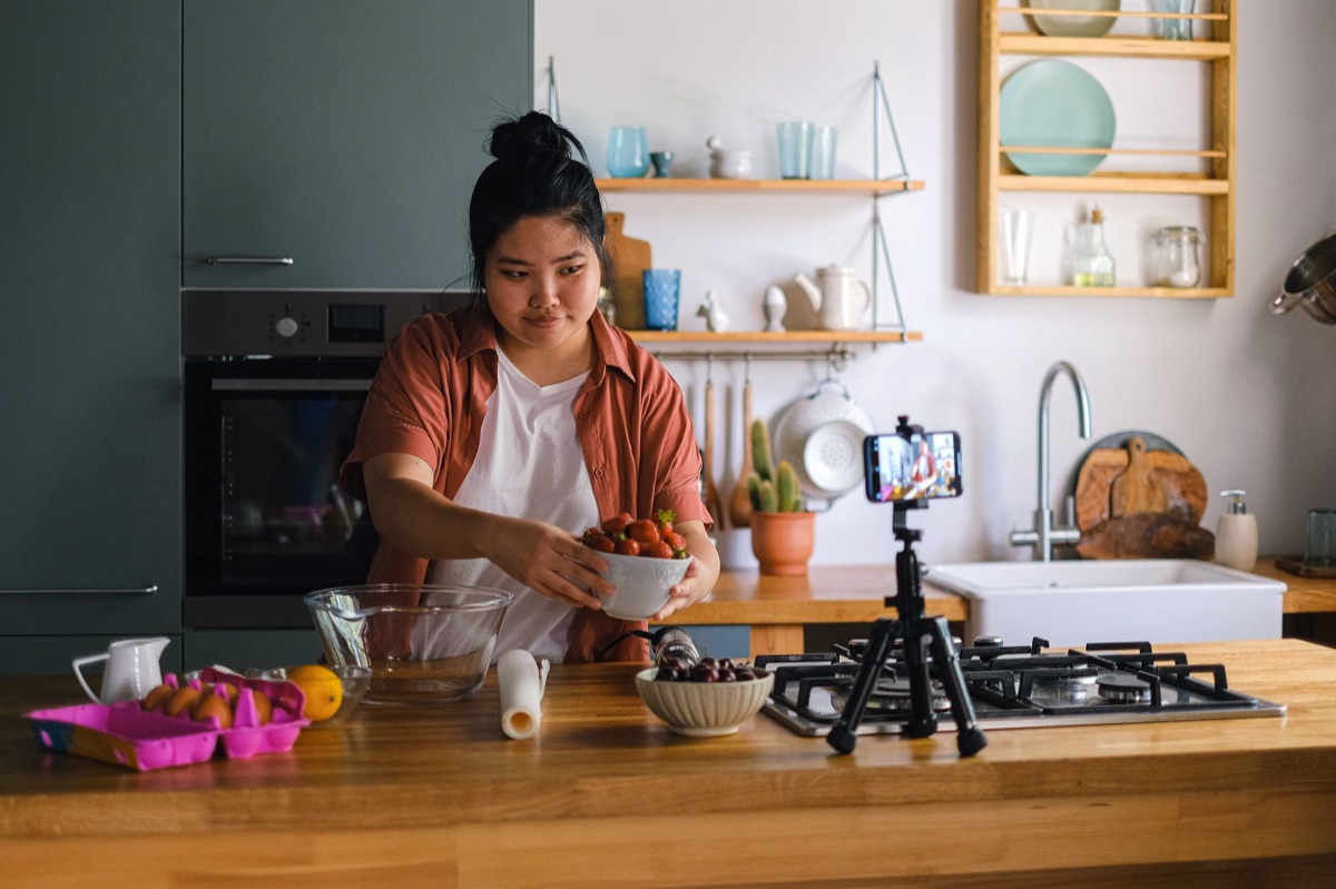 un influencer indonesiano in un studio con una telecamera e un cellulare