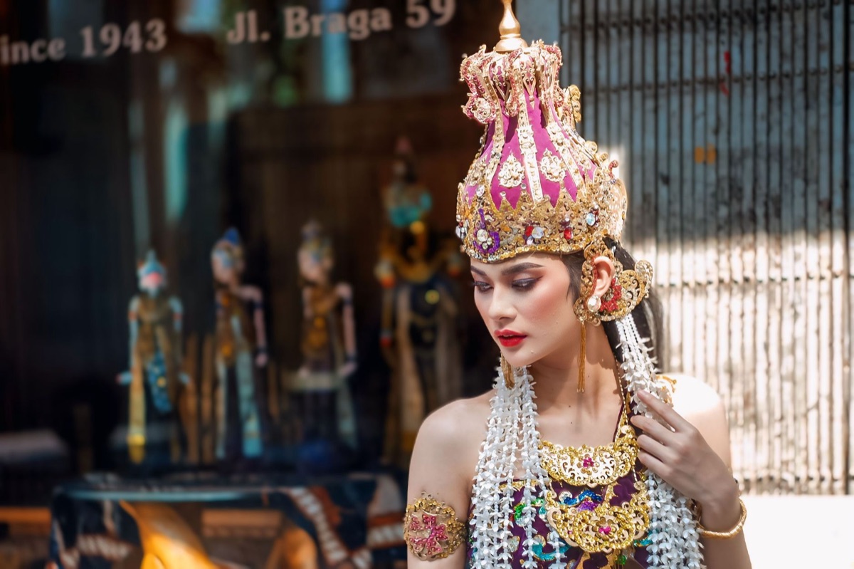 modelo indonesiana em roupa tradicional com câmera moderna
