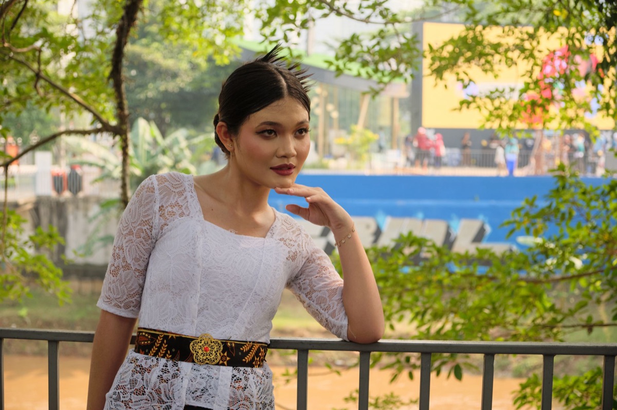 Indonesian influencer in urban setting with digital signage